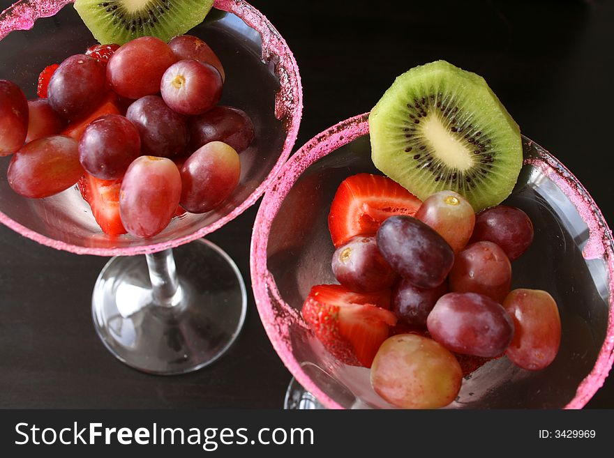 Fruit Salad in glasses with pink sugar crystal on the edge of the glass. Fruit Salad in glasses with pink sugar crystal on the edge of the glass