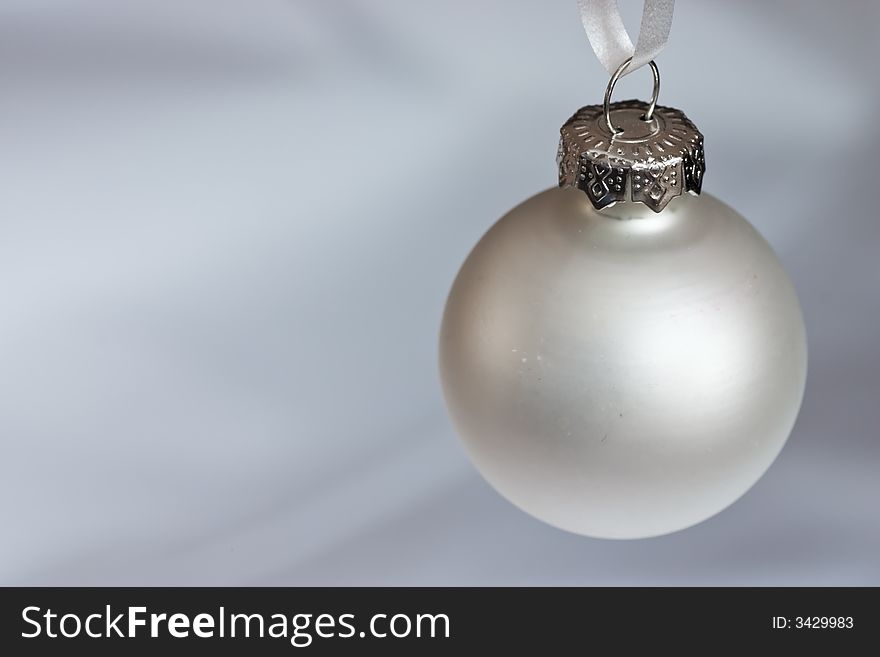 Silver christmas bauble on a silver/white background. Silver christmas bauble on a silver/white background