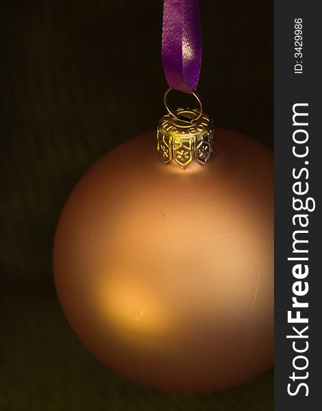 Golden christmas bauble in a dark setting. Golden christmas bauble in a dark setting