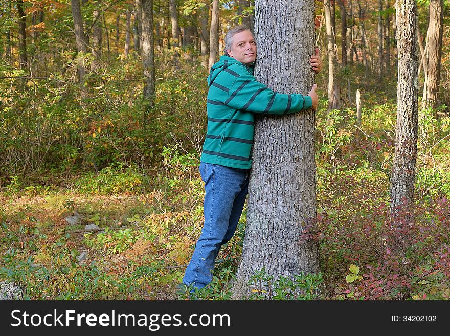 Man shown hugging tree expressing love for nature and environment. Man shown hugging tree expressing love for nature and environment.