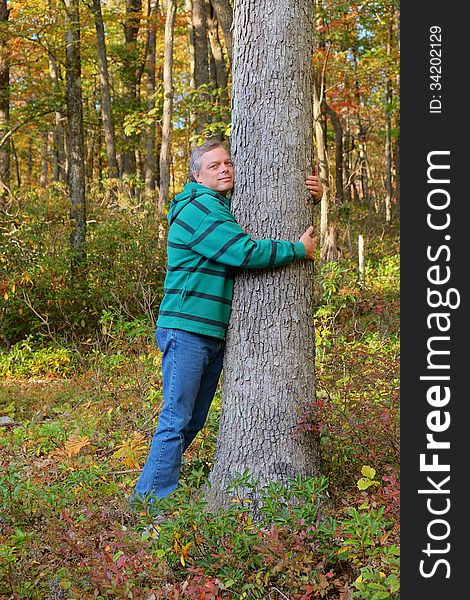 Man shown hugging tree expressing love for nature and environment. Man shown hugging tree expressing love for nature and environment.