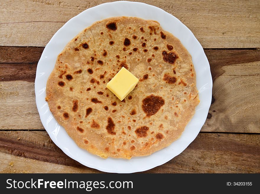 Stack of Indian Parantha (stuffed Indian bread) a plate with butter. Stack of Indian Parantha (stuffed Indian bread) a plate with butter