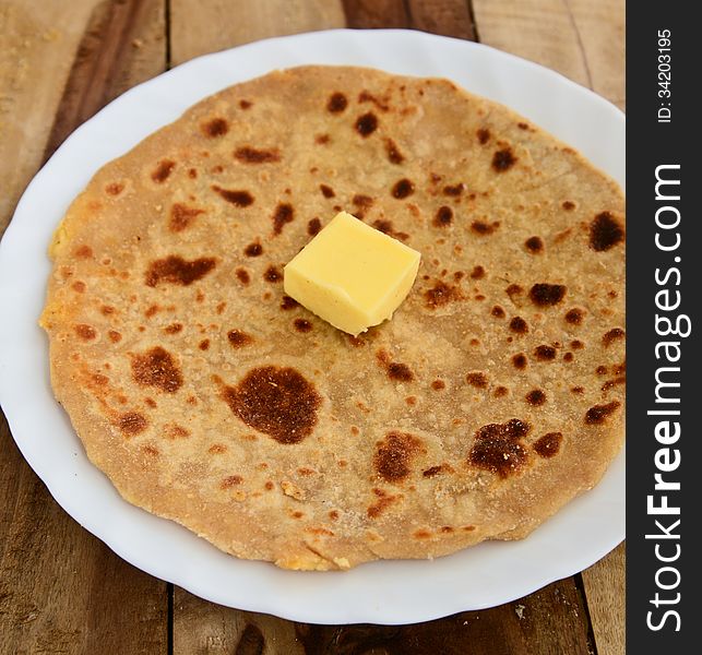 Stack of Indian Parantha (stuffed Indian bread) a plate with butter. Stack of Indian Parantha (stuffed Indian bread) a plate with butter