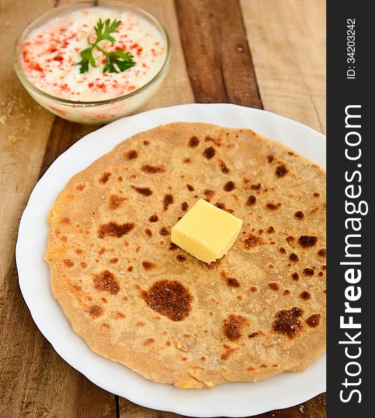 Stack of Indian Parantha (stuffed Indian bread) a plate with butter. Stack of Indian Parantha (stuffed Indian bread) a plate with butter