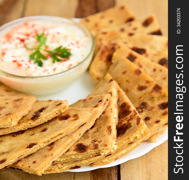 Stack of Indian Parantha (stuffed Indian bread) a plate with Curd. Stack of Indian Parantha (stuffed Indian bread) a plate with Curd