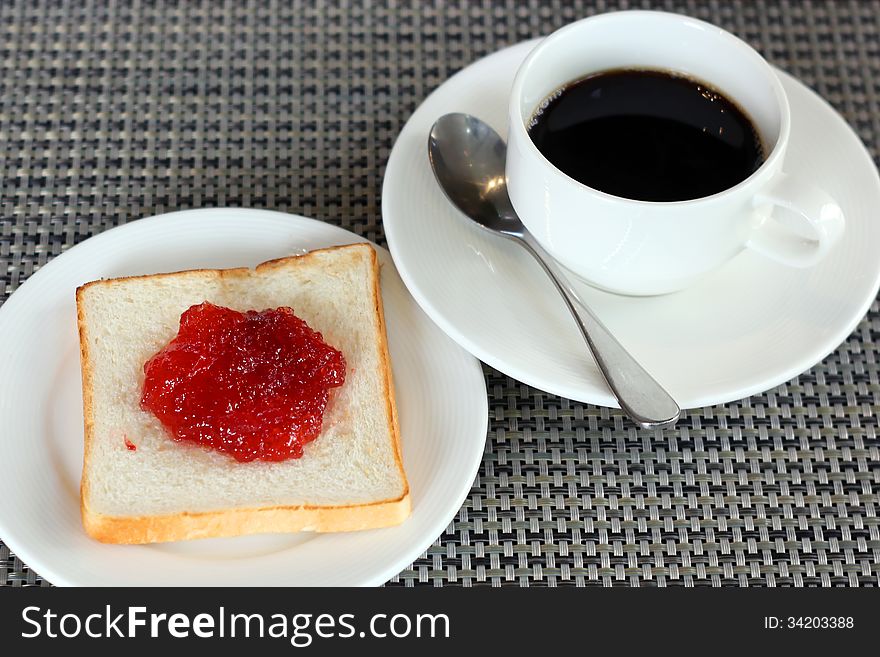 Strawberry jam on bread and coffee