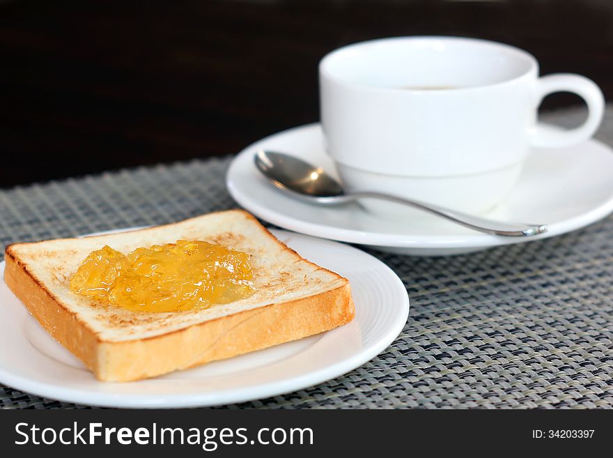 Pineapple jam on bread and coffee cup