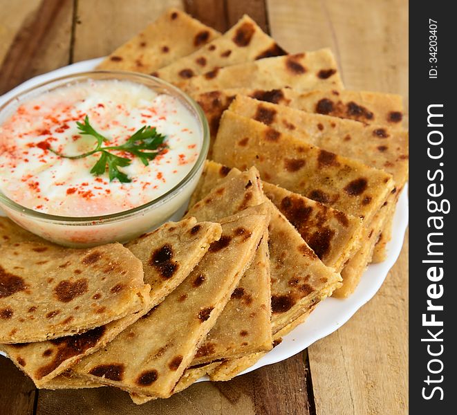 Stack of Indian Parantha (stuffed Indian bread) a plate with Curd. Stack of Indian Parantha (stuffed Indian bread) a plate with Curd