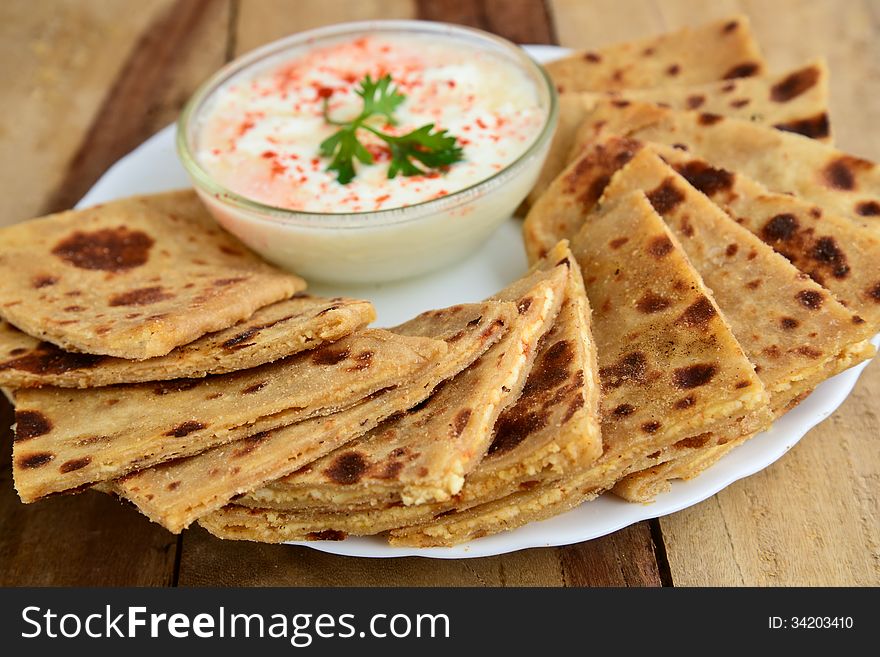 Stack of Indian Parantha (stuffed Indian bread) a plate with Curd. Stack of Indian Parantha (stuffed Indian bread) a plate with Curd