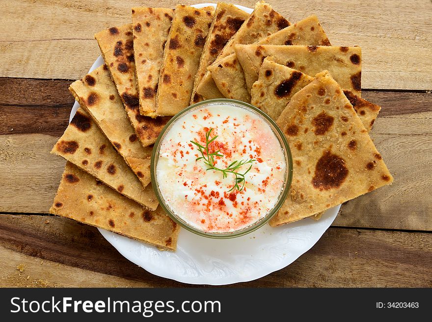 Stack of Indian Parantha (stuffed Indian bread) a plate with Curd. Stack of Indian Parantha (stuffed Indian bread) a plate with Curd