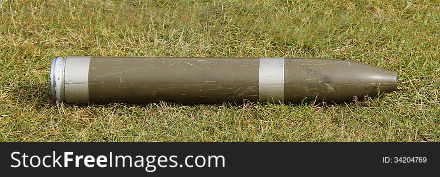 A Display Military Artillery Shell Laying on the Grass. A Display Military Artillery Shell Laying on the Grass.