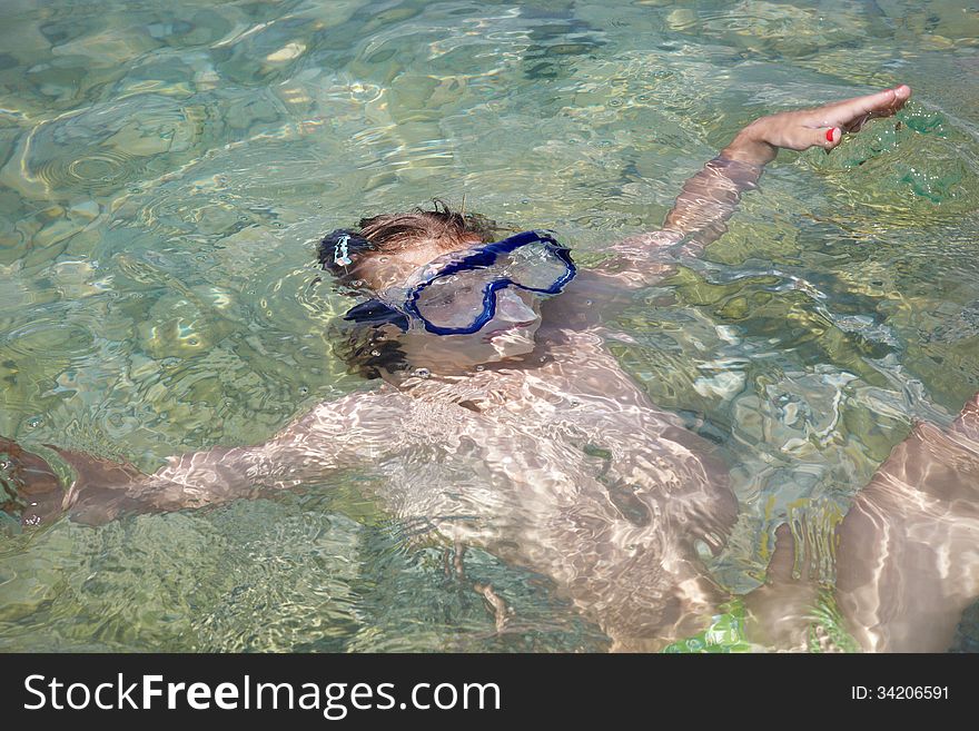 Little girl lying in sea at summer