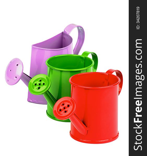 Arrangement of Red, Green and Purple Little Watering-Can isolated on white background