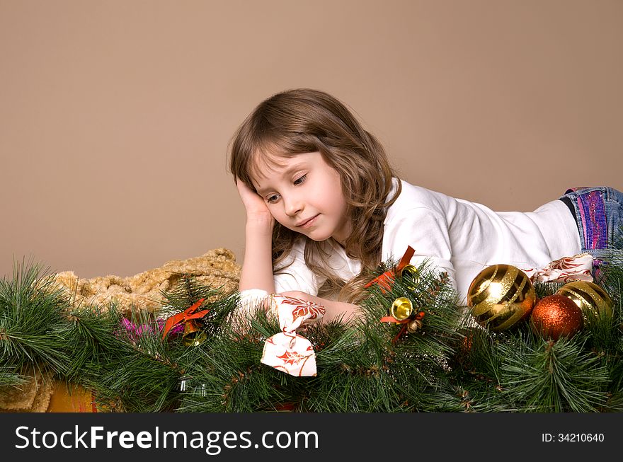 Child is lying and dreaming near tree decorations on eve of Christmas. Child is lying and dreaming near tree decorations on eve of Christmas