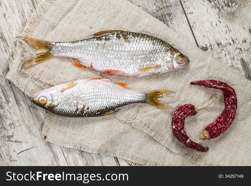 Two roaches fish on a linen napkin, near the old cutlery. From the series Still Life with fresh fish. Two roaches fish on a linen napkin, near the old cutlery. From the series Still Life with fresh fish