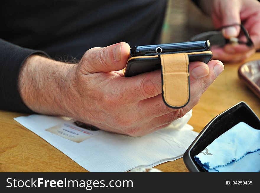 Mobile phone and glasses in the hands of men. Mobile phone and glasses in the hands of men