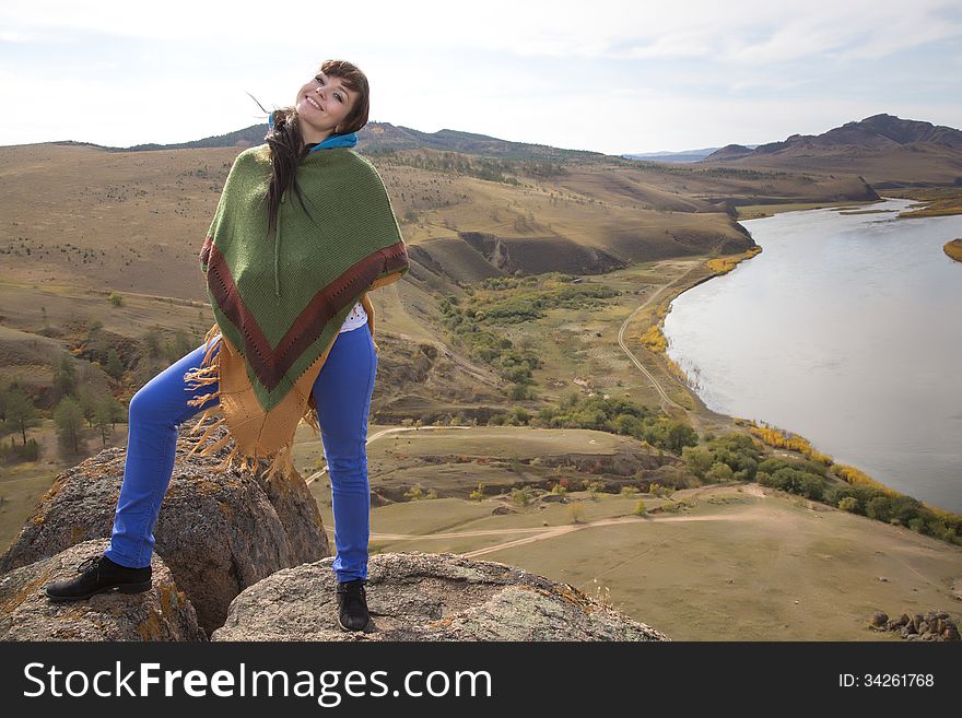 Beautiful woman posing on a rock in the mountains with lake. Beautiful woman posing on a rock in the mountains with lake