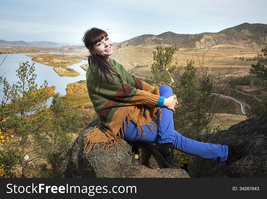 Beautiful woman posing on a rock in the mountains with lake. Beautiful woman posing on a rock in the mountains with lake