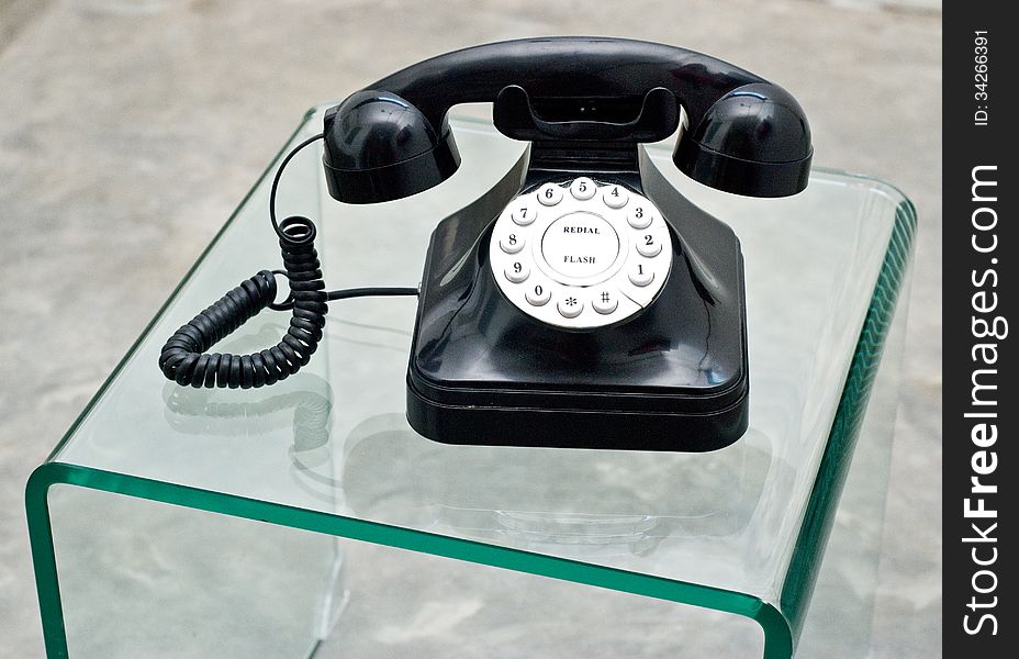 Black retro telephone on glass table