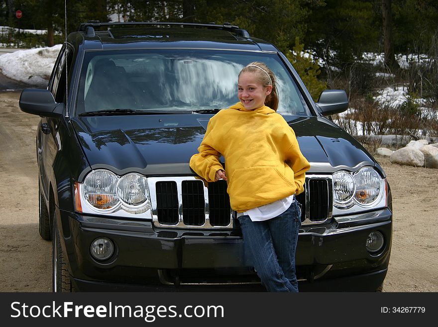 Teen girl standing in front of an SUV