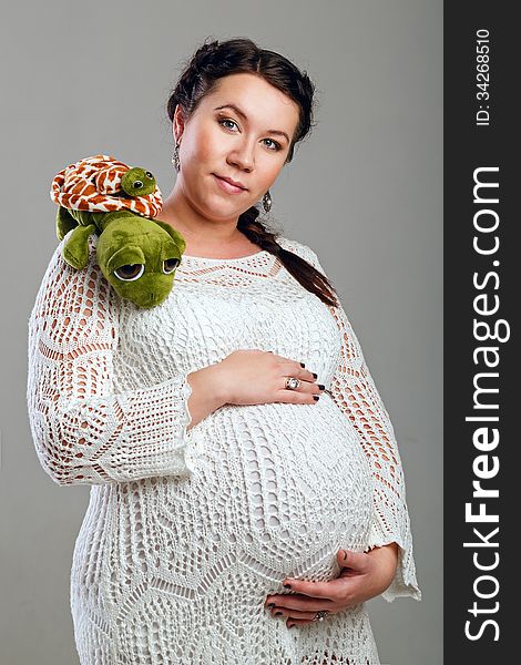 Attractive pregnant girl in a beautiful dress, shot in the studio. Attractive pregnant girl in a beautiful dress, shot in the studio