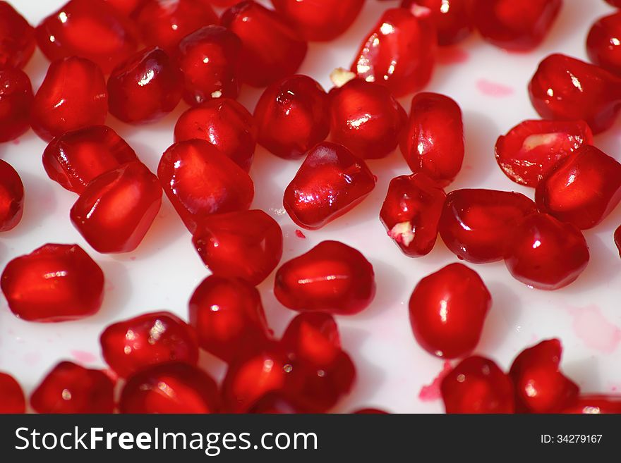 Pomegranate seeds spread on a white plate