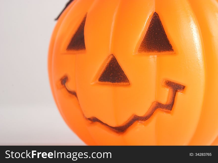 Macro of plastic pumpkin with a carved happy face