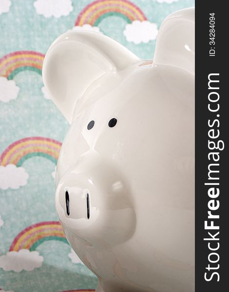 White ceramic piggy bank against a rainbow decorative background. White ceramic piggy bank against a rainbow decorative background