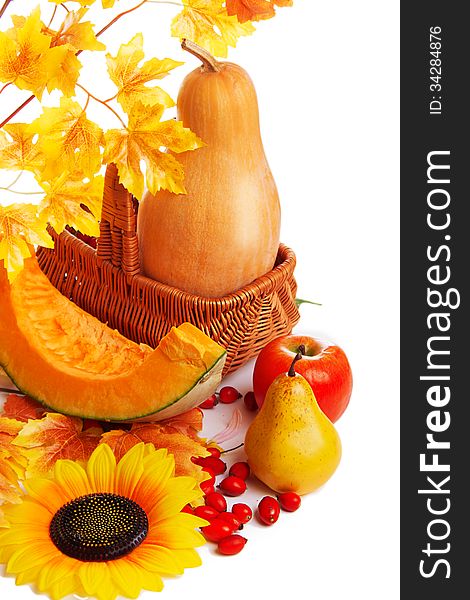 Autum harvest fruits and vegetables in basket with yellow leaves isolated on white