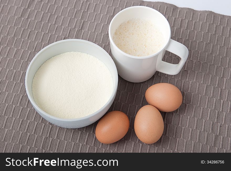 Dried albumin and eggs with dissolve albumin in a white cup on tablecloth. Dried albumin and eggs with dissolve albumin in a white cup on tablecloth.