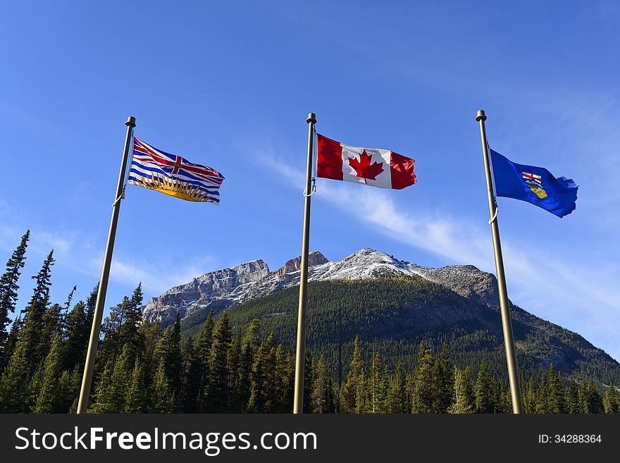 Canadian national flag, British Columbia provincial flag and Alberta provincial flag at the provincial border, Canada;. Canadian national flag, British Columbia provincial flag and Alberta provincial flag at the provincial border, Canada;