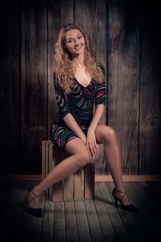 Shiny Smiling Girl Sitting On The Box Over Wooden Wall Backgound Stock Photo Shiny Smiling Girl Sitting On The Box Over Wooden Wall Backgound Stock Photo