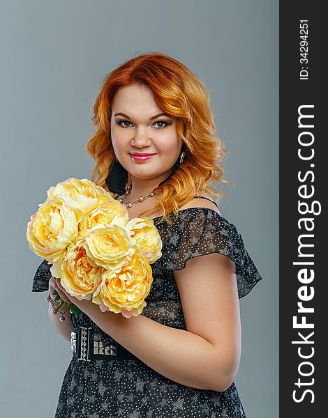 Attractive red-haired girl holding a bouquet of yellow flowers. Attractive red-haired girl holding a bouquet of yellow flowers