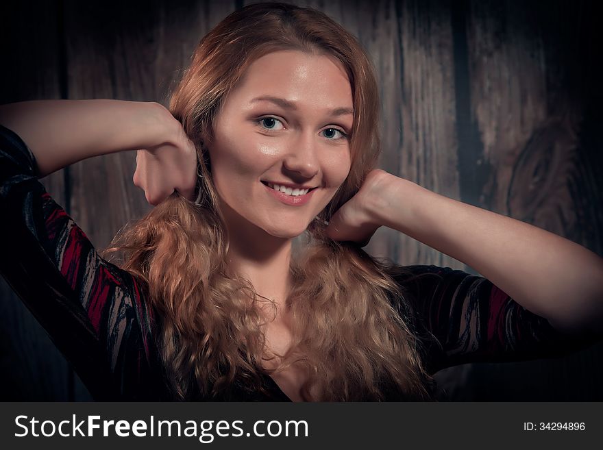 Portrait of natural looking young woman with healthy facial skin, long golden blond hair, big beautiful eyes. Over wooden wall background. Portrait of natural looking young woman with healthy facial skin, long golden blond hair, big beautiful eyes. Over wooden wall background.