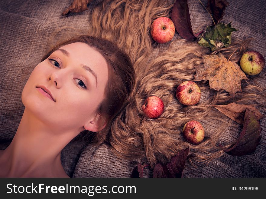 Dreamy autumn girl with leaves and fruits in her hair