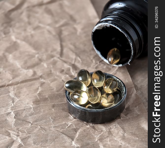 Inverted black bottle with capsules, closeup. Inverted black bottle with capsules, closeup