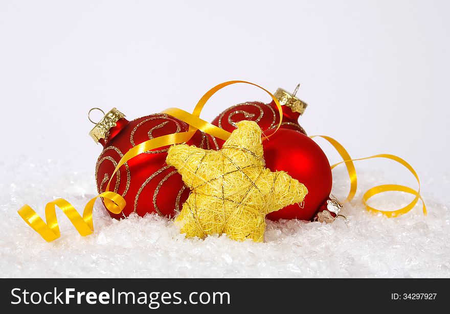 Red-golden baubles and yellow star on the snow. Red-golden baubles and yellow star on the snow