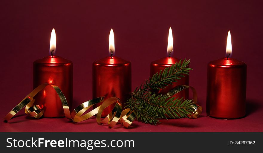 Four burning red candles in a row