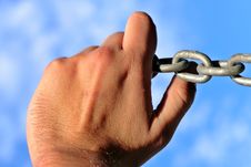 Hand Holding Chain Against Sky Royalty Free Stock Image