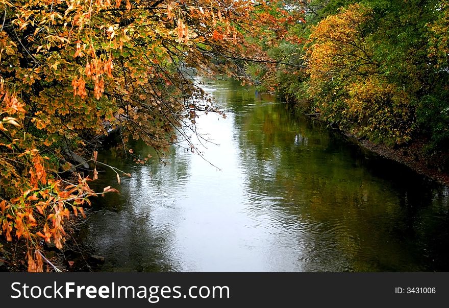 Canal passing through colorful trees during autumn time