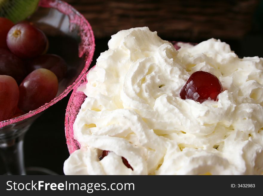 Cherry and cream on top of a fruit salad. Cherry and cream on top of a fruit salad