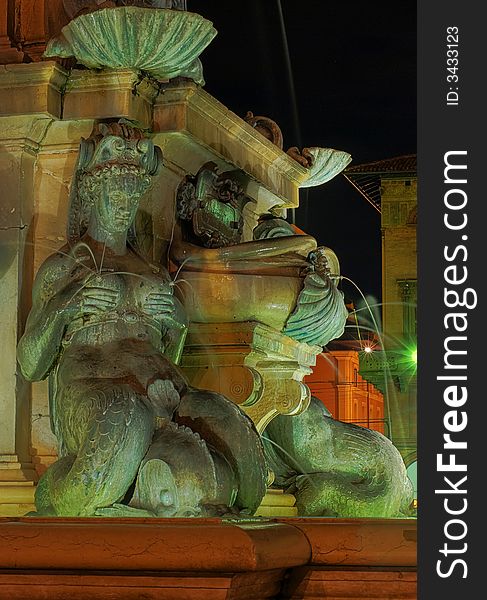 A detail of the reinassance Neptune Fountain in Bologna, Italy, colored by the lights during the night. A detail of the reinassance Neptune Fountain in Bologna, Italy, colored by the lights during the night.