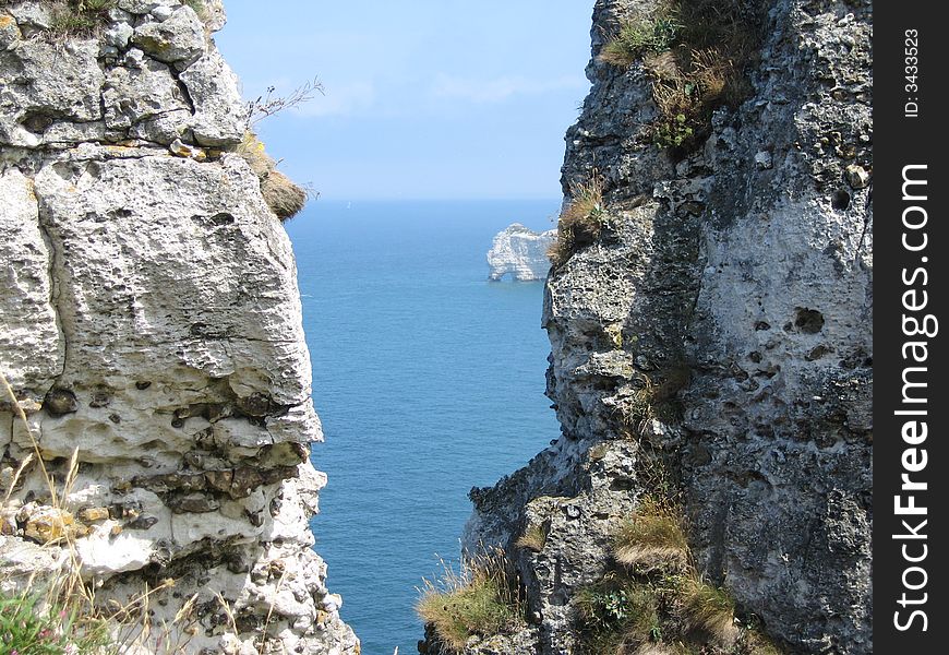 You can see a smal piece of the sea through two big rocks. There is a gate in the rock. You can see a smal piece of the sea through two big rocks. There is a gate in the rock.