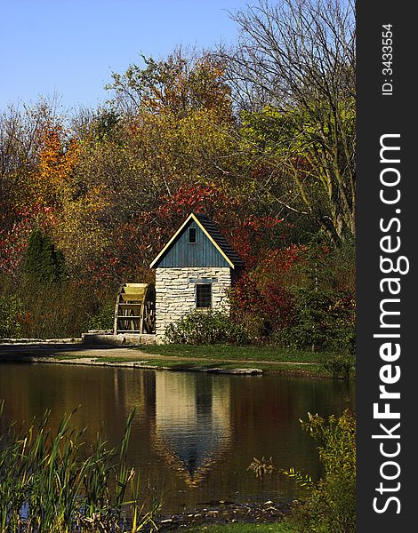 Stone watermill beside a pond during the autumn season.