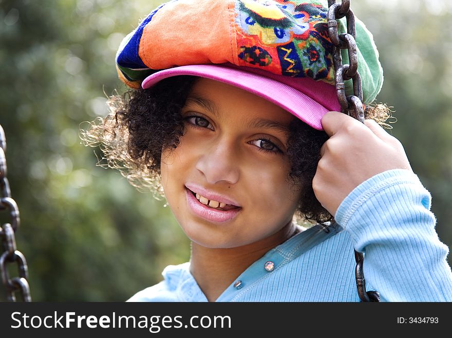 Image of a biracial girl on a swing and backlit by the sun. Image of a biracial girl on a swing and backlit by the sun