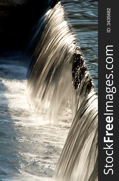 Water flowing over the edge in a pond. Water flowing over the edge in a pond