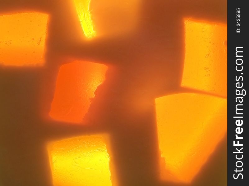 Full frame photograph of yellow and orange handmade glycerin soap with a light shining through it giving it an abstract glow. Full frame photograph of yellow and orange handmade glycerin soap with a light shining through it giving it an abstract glow.