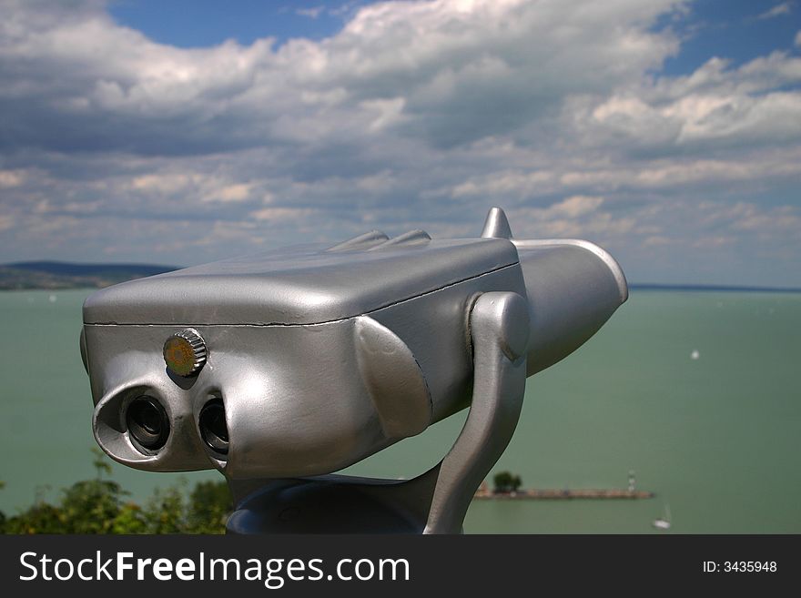 Binoculars with lake Balaton and clouds in the background. Binoculars with lake Balaton and clouds in the background.