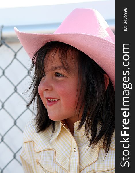 Little cowgirl hanging out by a chain fence. Little cowgirl hanging out by a chain fence