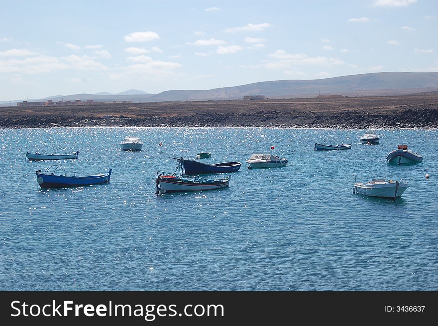 Lagoon on lava island Fuerteventura, Canaries, where small fishing boats are anchoring. Lagoon on lava island Fuerteventura, Canaries, where small fishing boats are anchoring.